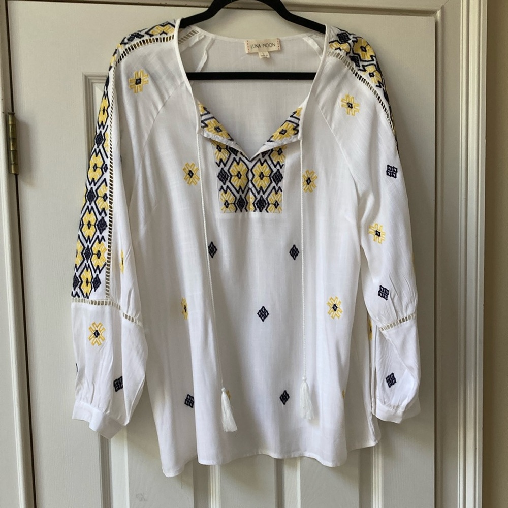 Luna Moon Long  sleeve pullover top. Yellow and blue embroidery on a white top.
